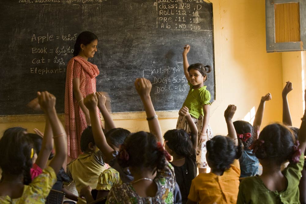 Children raising their hands in an RDT supplementary school class